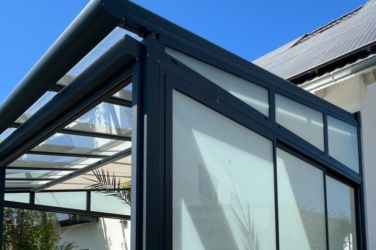 Terrassenüberdachung mit Glas-Schiebeelementen und Seitenschutz