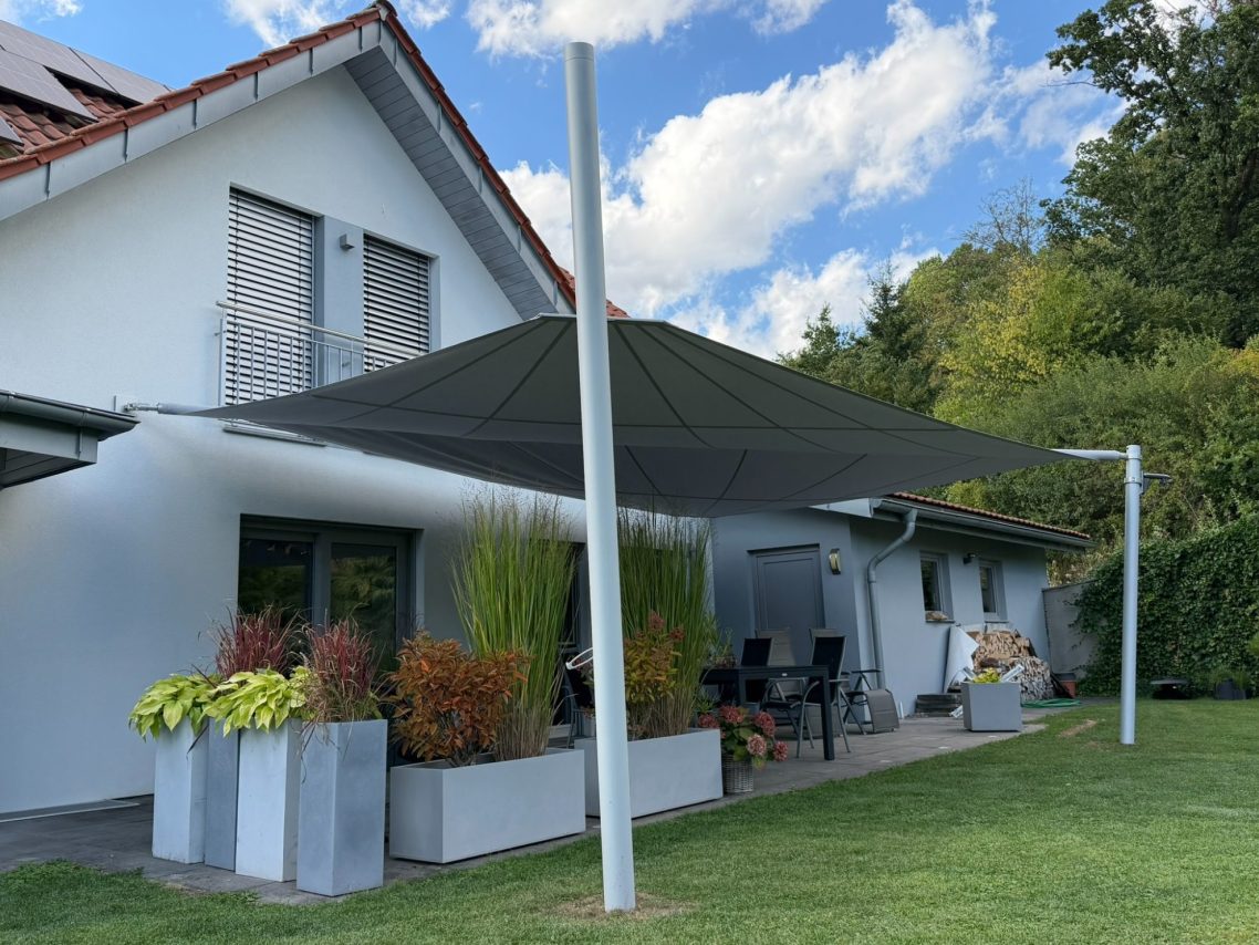 Aufrollbares Sonnensegel an einem Aluminiummast im Garten